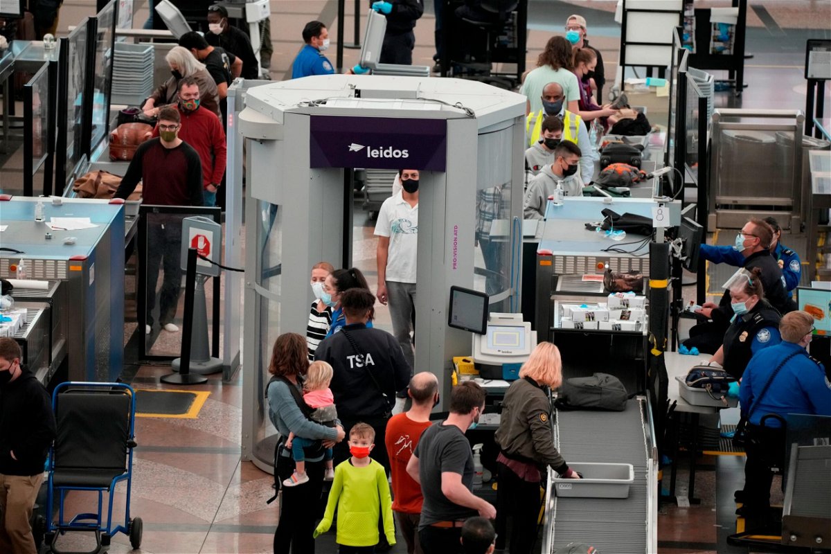 <i>David Zalubowski/AP</i><br/>Christmas Eve air travel is well below 2019 levels amid flight cancellations as Omicron cases surge. Pictured are travelers at the Denver International Airport Friday