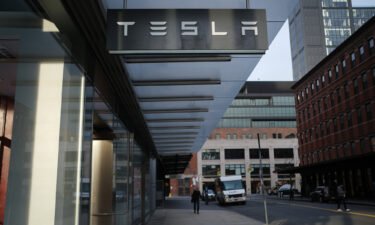 Tesla is under regulatory investigation after a whistleblower alleged the company failed to properly disclose fire risks associated with solar panel defects as a Tesla sign is displayed outside of a showroom at a Manhattan dealership on January 30