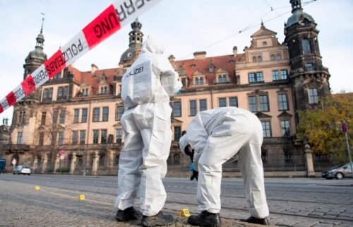 Two members of the forensic team are standing in front of the Residence Palace with the Green Vault behind a barrier tape. Dresden's Treasury Green Vault was broken into