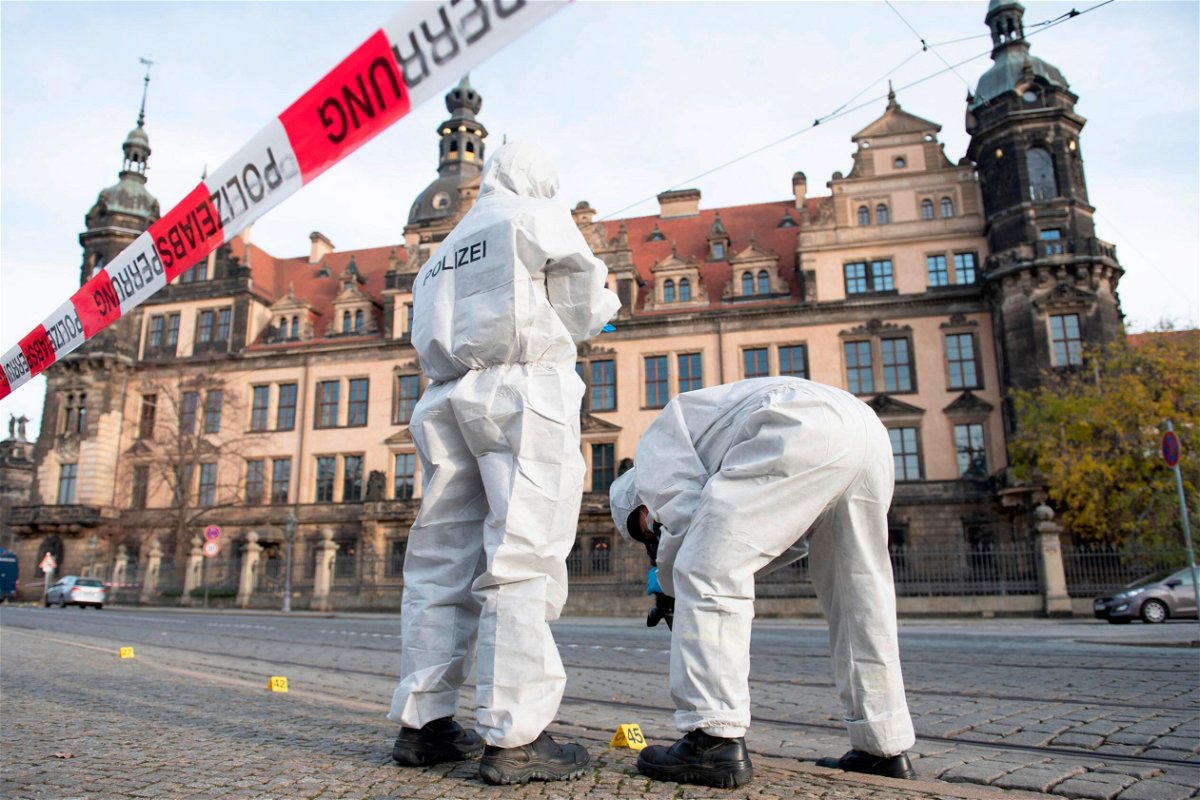 <i>Sebastian Kahnert/picture-alliance/dpa/AP</i><br/>Two members of the forensic team are standing in front of the Residence Palace with the Green Vault behind a barrier tape. Dresden's Treasury Green Vault was broken into