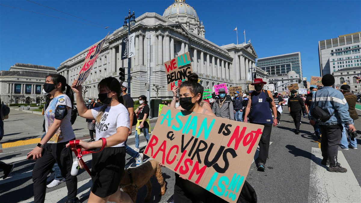 <i>Ray Chavez/MediaNews Group/The Mercury News via Getty Images</i><br/>Demonstrators hold up signs as they take part in an anti-Asian American hate march and rally at San Francisco City Hall in San Francisco last year.
