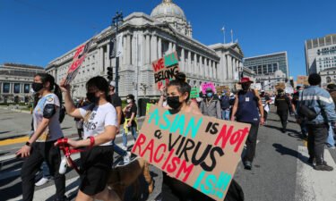 Demonstrators hold up signs as they take part in an anti-Asian American hate march and rally at San Francisco City Hall in San Francisco last year.