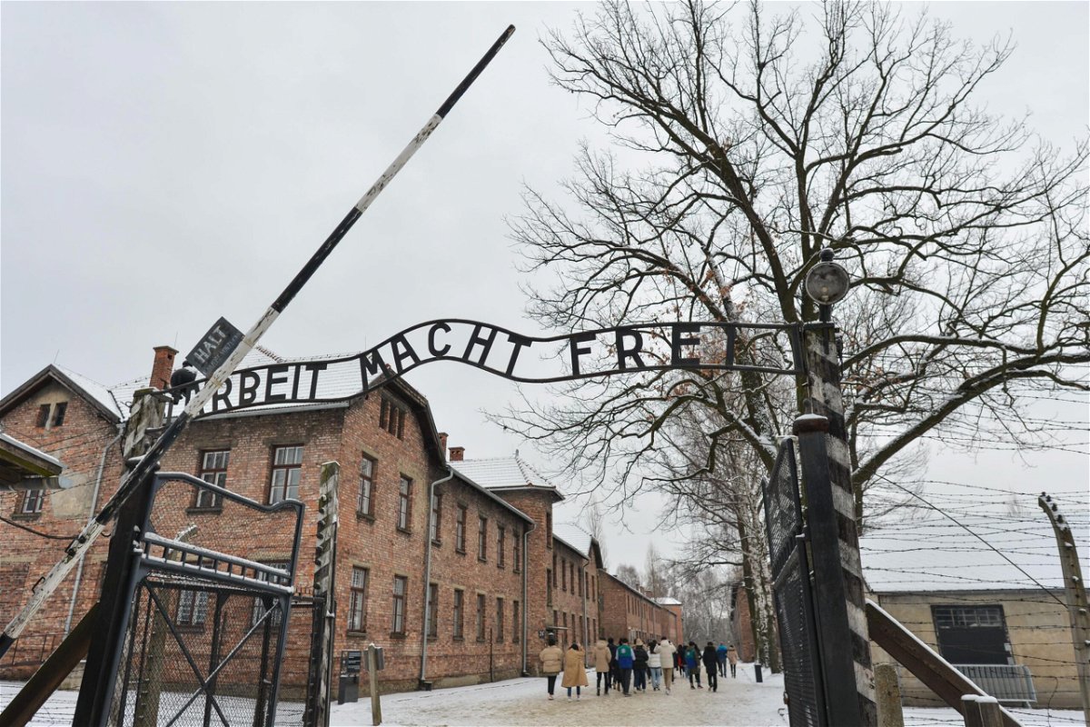 <i>Artur Widak/NurPhoto/Reuters</i><br/>The woman was posing for photos in front of this gate at Auschwitz-Birkenau.