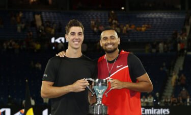 Thanasi Kokkinakis and Nick Kyrgios pose with the championship trophy after winning their men's doubles final.