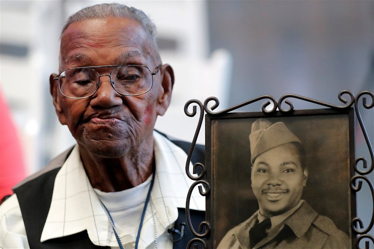 <i>Gerald Herbert/AP</i><br/>World War II veteran Lawrence Brooks holds a photo of him taken in 1943