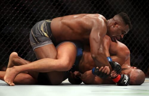 Ngannou grapples on the ground with Gane.