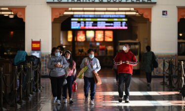 A family wearing face masks walks through Union Station in Los Angeles.