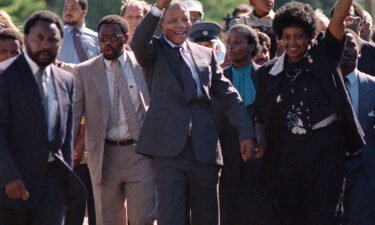 Nelson Mandela and his wife Winnie salute a cheering crowd upon his release from prison on February 11
