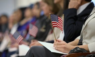 Immigrants hold flags while waiting for a naturalization ceremony to become U.S. citizens at the district office of U.S. Citizenship and Immigration Services (USCIS) on January 28