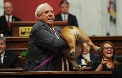 West Virginia Gov. Jim Justice holds up his dog Babydog's rear end as a message to people who've doubted the state as he comes to the end of his State of the State speech in the House chambers