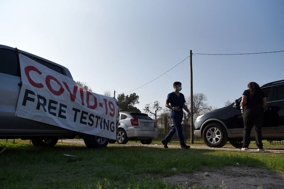 <i>Callaghan O'Hare/Reuters</i><br/>Healthcare workers operate a COVID-19 drive-through testing site as the Omicron variant of the coronavirus continues to spread through the country in Houston