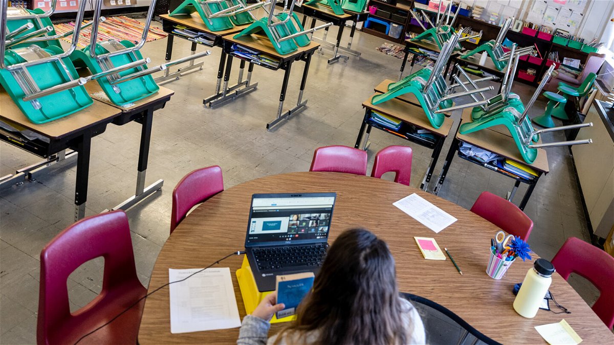 <i>Jon Cherry/Getty Images</i><br/>A teacher interacts with students virtually while sitting in an empty classroom during a period of Non-Traditional Instruction (NTI) at Hazelwood Elementary School on January 11