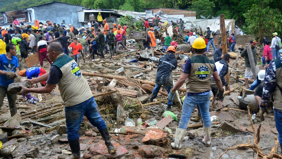 <i>Andres Otalvaro/AP</i><br/>Neighbors join rescue workers in the hunt for survivors after a rain-weakened hillside collapsed over homes in Pereira