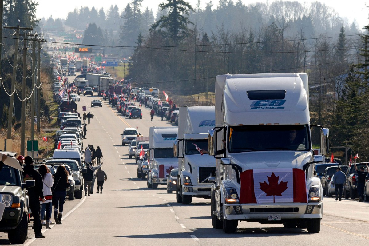<i>Jason Redmond/AFP/Getty Images</i><br/>Trucks displaying the Canadian national flag drive by as anti-vaccine mandate and anti-government protesters demonstrate on February 12 on Highway 15 near the Pacific Highway Border Crossing on the US-Canada border with Washington State in Surrey