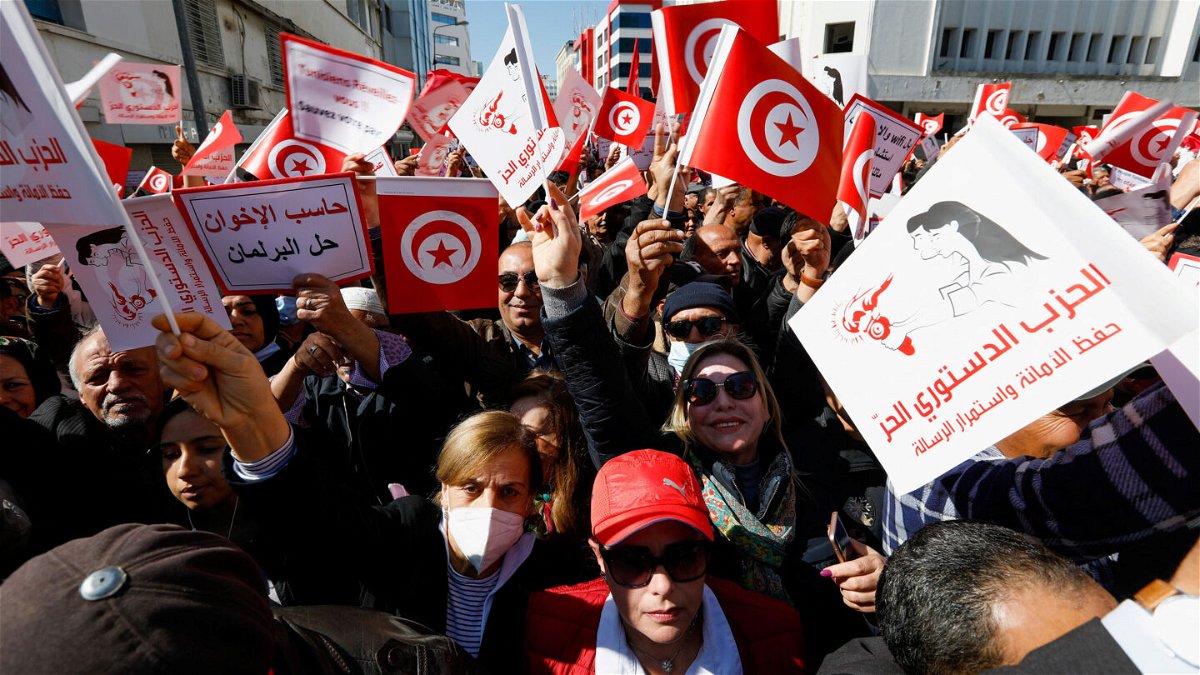 <i>Zoubeir Souissi/Reuters</i><br/>Demonstrators hold placards and Tunisian national flags during a protest March 13 in Tunis against President Kais Saied's seizure of governing powers.