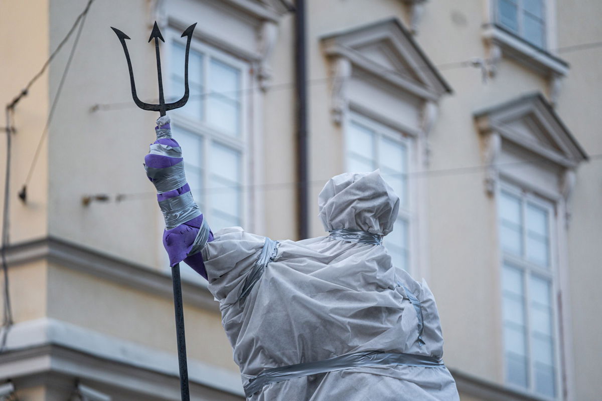 <i>Pau Venteo/Europa Press/Getty Images</i><br/>A statue of Roman god Neptune stands covered in protective plastic in Lviv's Market Square.