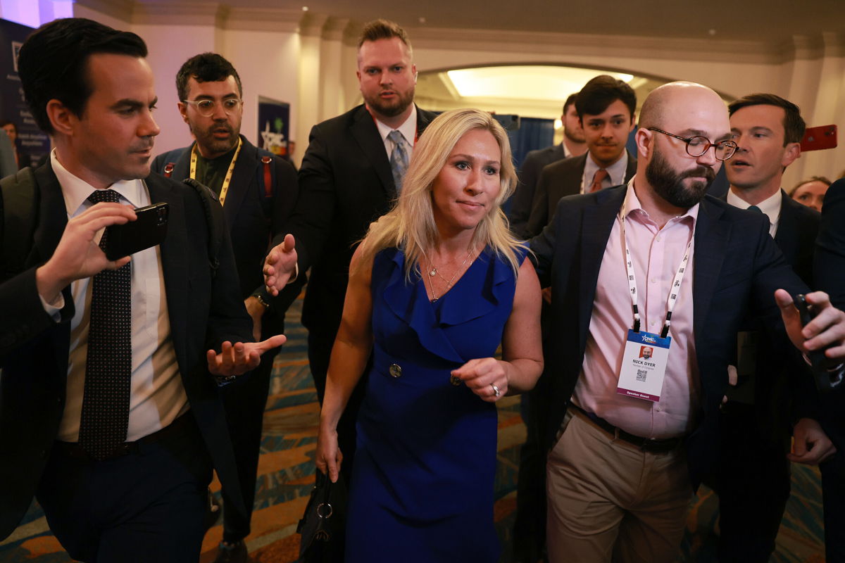 <i>Joe Raedle/Getty Images</i><br/>Rep. Marjorie Taylor Greene (R-GA) is escorted through a throng of media as she attends the CPAC on February 26 in Orlando