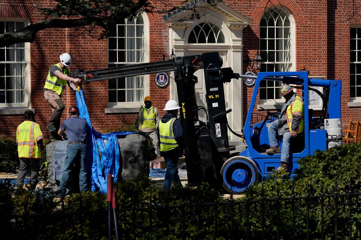 <i>Julio Cortez/AP</i><br/>Workers removing the base of the Confederate statue on Monday.