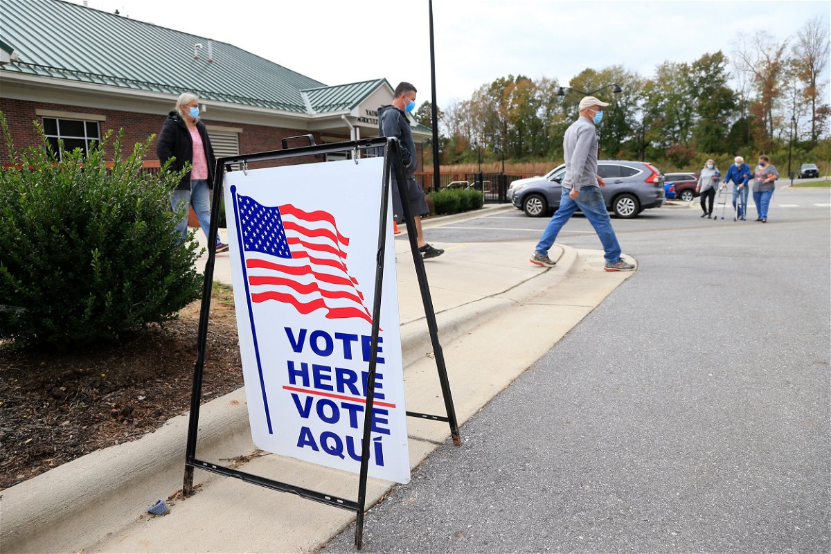 <i>Brian Blanco/Getty Images/FILE</i><br/>Voters arrive and depart a polling place on October 31