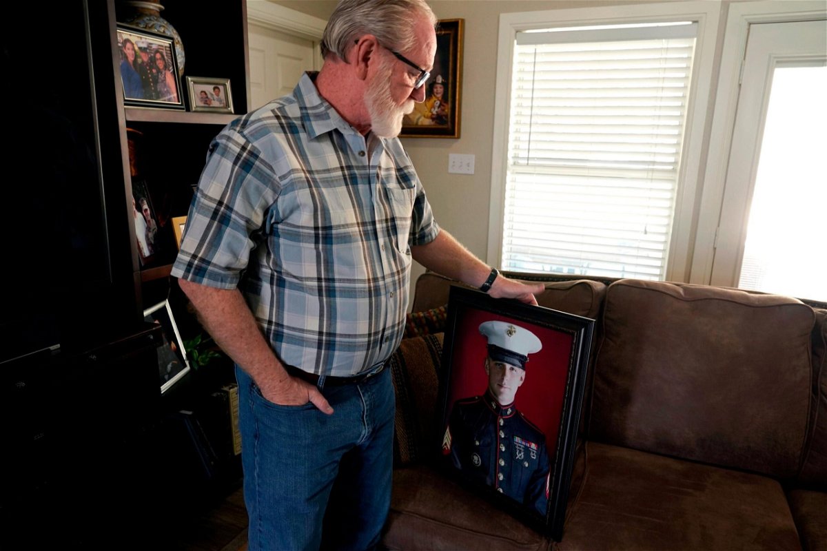 <i>LM Otero/AP</i><br/>Joey Reed holds a portrait of his son Marine veteran and Russian prisoner Trevor Reed at his home in Fort Worth
