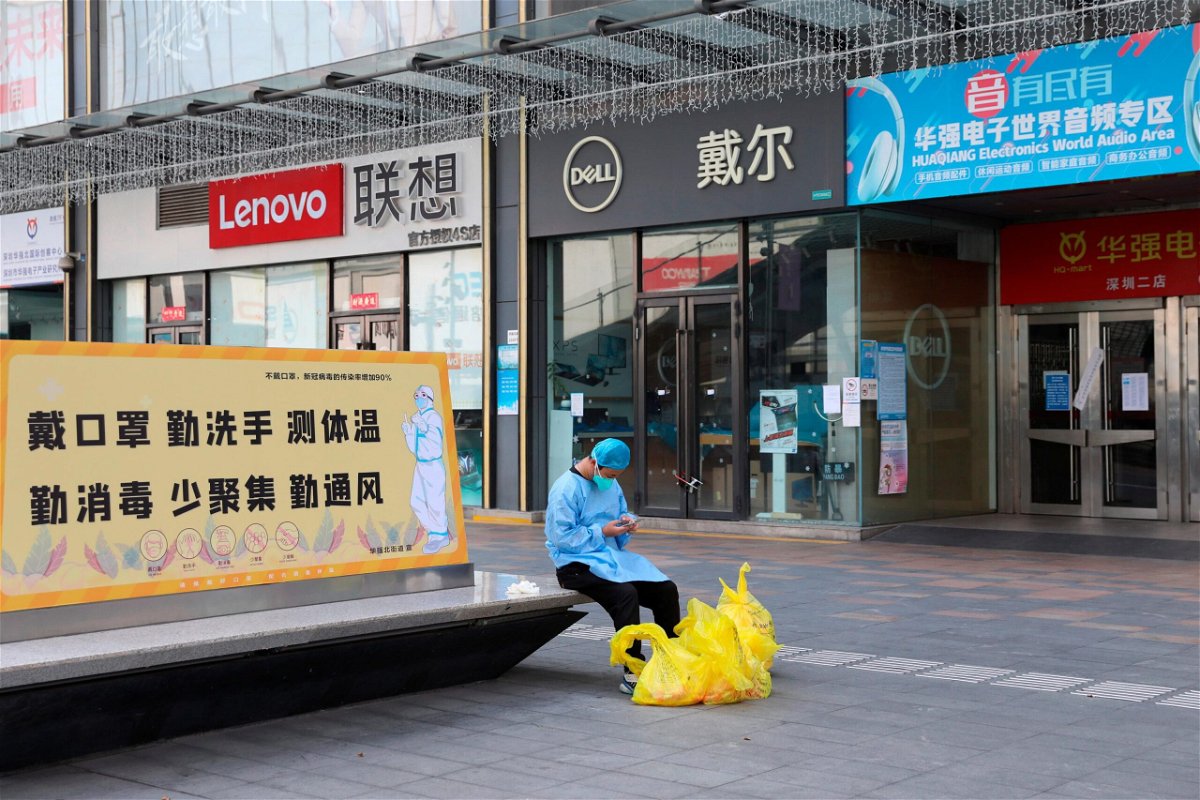 <i>FeatureChina/AP</i><br/>A janitor checks his phone outside closed shops in Huaqiangbei area
