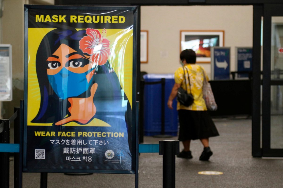 <i>Caleb Jones/AP</i><br/>A poster at the international airport in Honolulu in 2020 showing mask requirement.