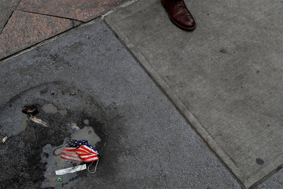 <i>Shannon Stapleton/Reuters</i><br/>A protective face mask imprinted with the U.S. flag lays on the ground.