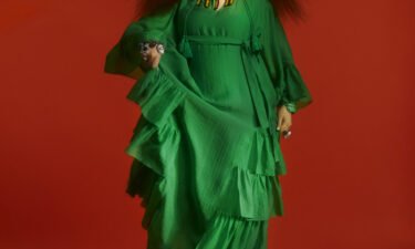 H&M has unveiled its "playfully over-the-top" collaboration with renowned interior designer and longtime style icon Iris Apfel. This green tiered kaftan is a highlight of the collection.