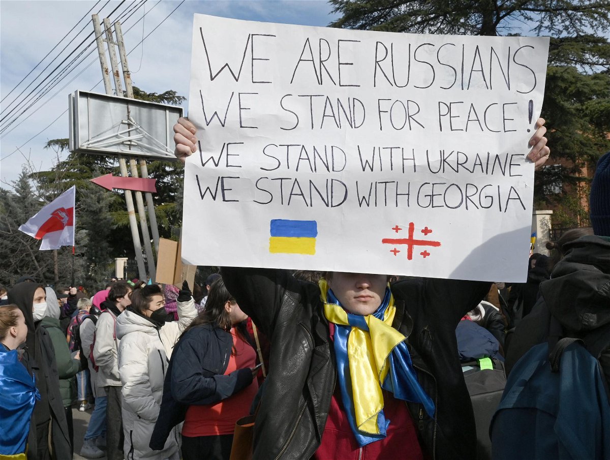 <i>Vano Shlamov/AFP/Getty Images</i><br/>An anti-war protester holds a placard during a rally in front of the former Russian embassy in Tbilisi on March 12.