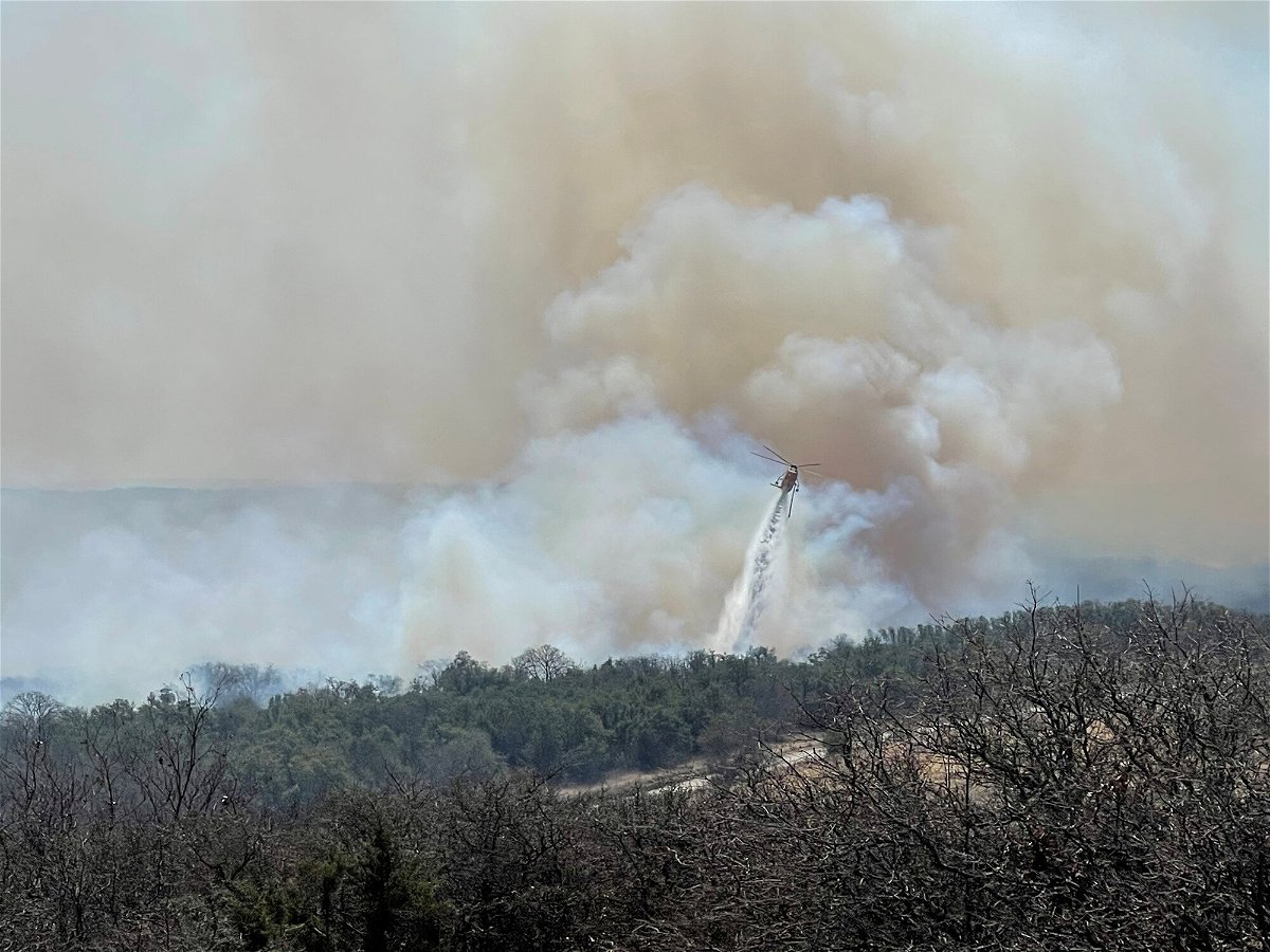 <i>Twitter/@johnnyhaysmd/Reuters</i><br/>A firefighting helicopter makes a water drop on the Eastland Complex wildfire near Rising Star