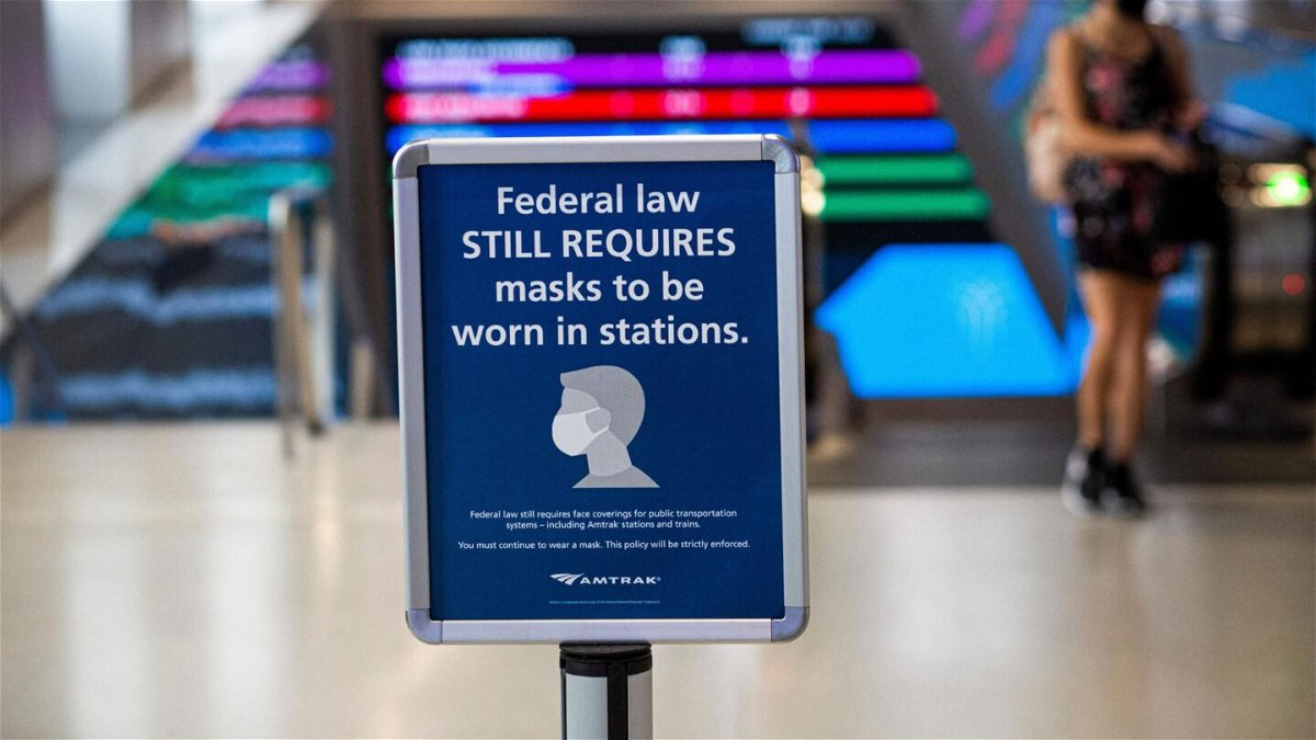 <i>Kena Betancur/AFP/Getty Images</i><br/>A woman walks past a sign calling for mask wearing at Penn station in New York on August 2