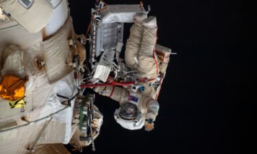 Cosmonaut Oleg Artemyev waves to the camera while working outside the Nauka multipurpose laboratory module during a spacewalk that lasted for six hours and 37 minutes to outfit Nauka and configure the European robotic arm on the International Space Station's Russian segment.