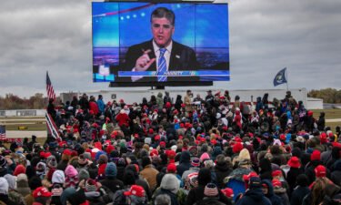Supporters of former President Donald Trump watch a video featuring Fox host Sean Hannity ahead of Trump's arrival at a campaign rally in Michigan in October 2020.