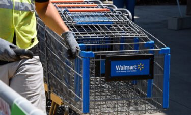 An employee gathers shopping carts at Walmart in July 2020 in Burbank