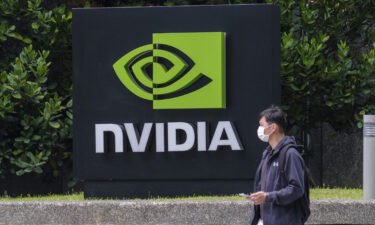 A man wearing a mask walks past an Nvidia logo in Taipei.
