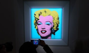 A guest takes a photo during Christie's announcement that it will offer Andy Warhol's "Shot Sage Blue Marilyn" painting for auction.