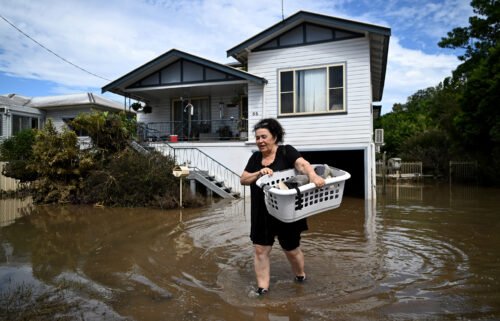 Patria Powell walks through floodwater after salvaging items from her mother's flood-affected home March 07