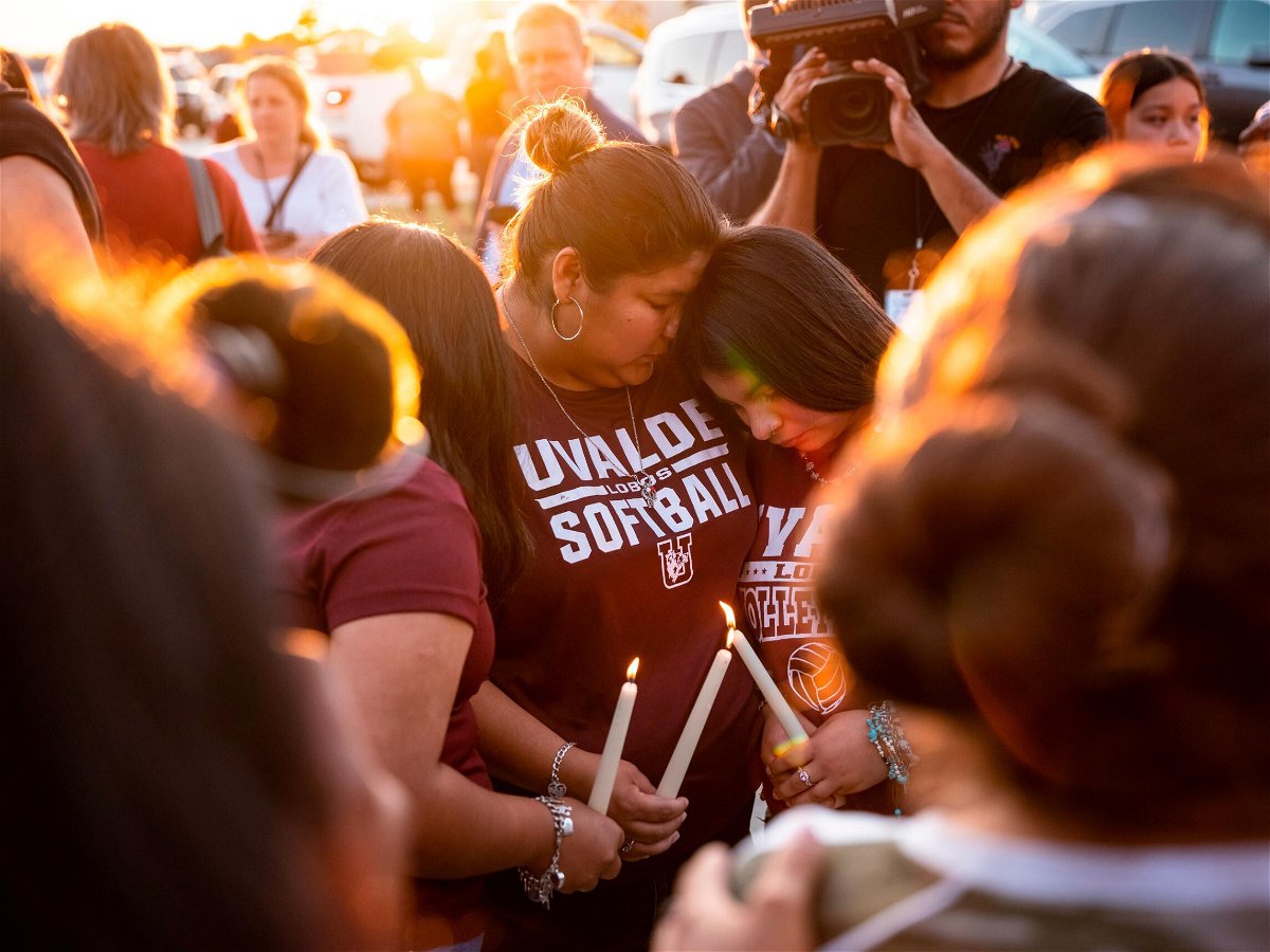 <i>Matthew Busch for CNN</i><br/>Attendees light candles during a memorial held for the 19 children and two teachers who were murdered by an 18-year-old gunman at Robb Elementary School the day before