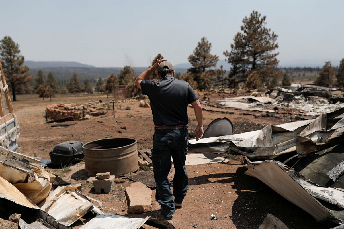 <i>Adria Malcolm/Reuters</i><br/>Michael Salazar walks through his property that was burned during the Hermits Peak and Calf Canyon fires in Tierra Monte