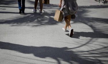 A pedestrian carries a shopping bag while walking in Miami