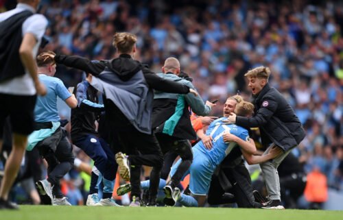 Kevin De Bruyne is mobbed by Manchester City fans after the club wins the Premier League.
