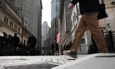People walk by the New York Stock Exchange on April 4