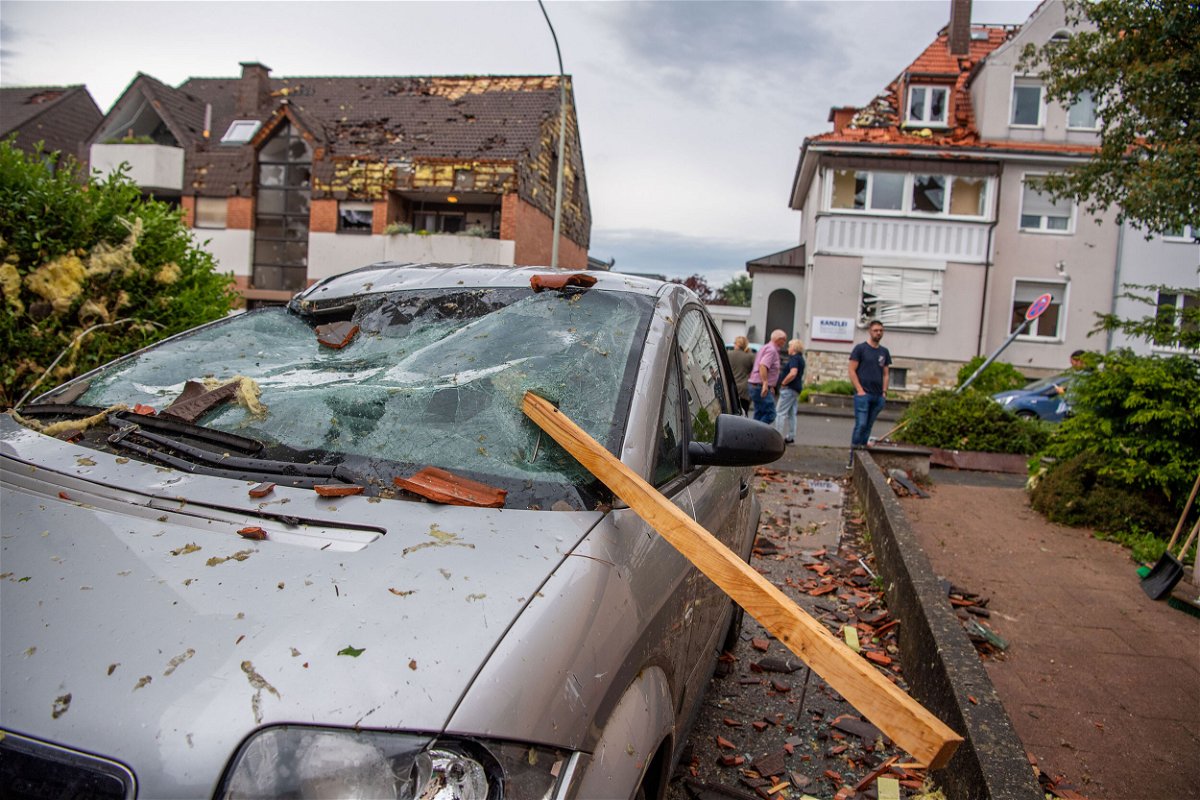 <i>Lino Mirgeler/picture alliance/Getty Images</i><br/>Parts of a roof are seen stuck in the windshield of a parked car.