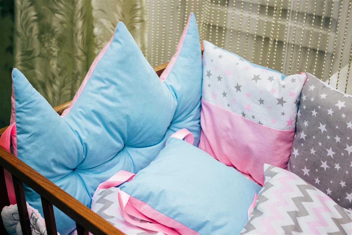 <i>Shutterstock</i><br/>Cots and pillows and bumpers of different colors. Turquoise pillow