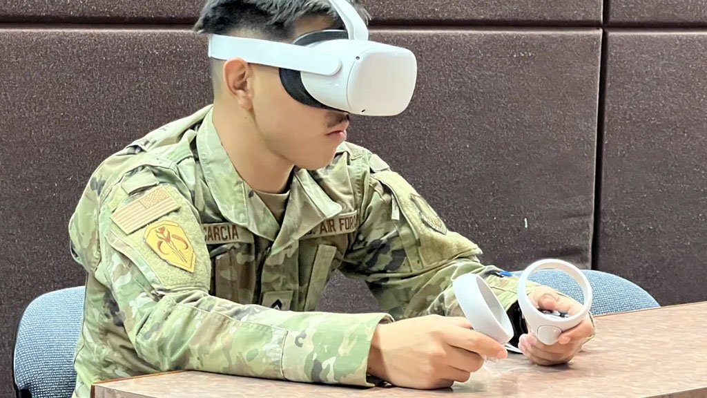 An Air Force ROTC cadet at the University of Texas at El Paso wears goggles while engaging in a voice-activated conversation with someone in crisis during a virtual reality training module.