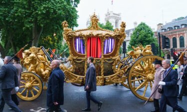 The gold state coach during an early morning rehearsal as service personnel from the Royal Navy