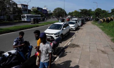 Motorists wait in a queue expecting to buy fuel in Colombo