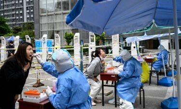 Health workers take swab samples to be tested for Covid-19 at a makeshift testing site along a street in Beijing on May 11.