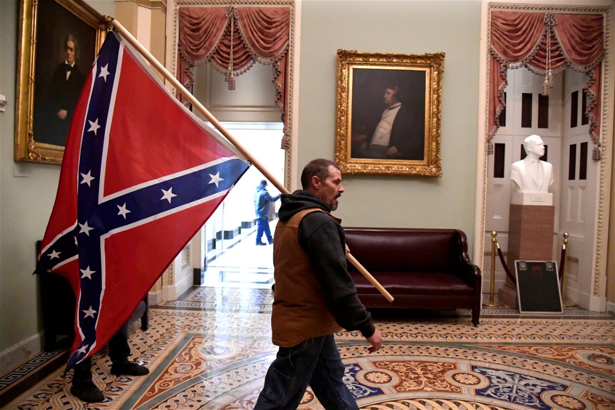 <i>Mike Theiler/Reuters</i><br/>Kevin Seefried carries a Confederate battle flag on the second floor of the U.S. Capitol on January 6