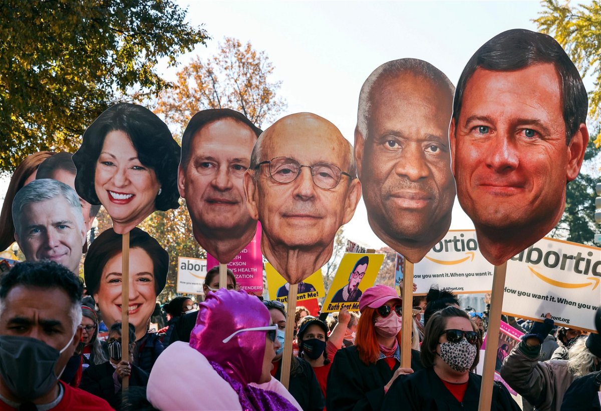 <i>Chip Somodevilla/Getty Images</i><br/>Activists with The Center for Popular Democracy Action hold photos of U.S. Supreme Court justices as they block an intersection during a demonstration in front of the U.S. Supreme Court on December 1
